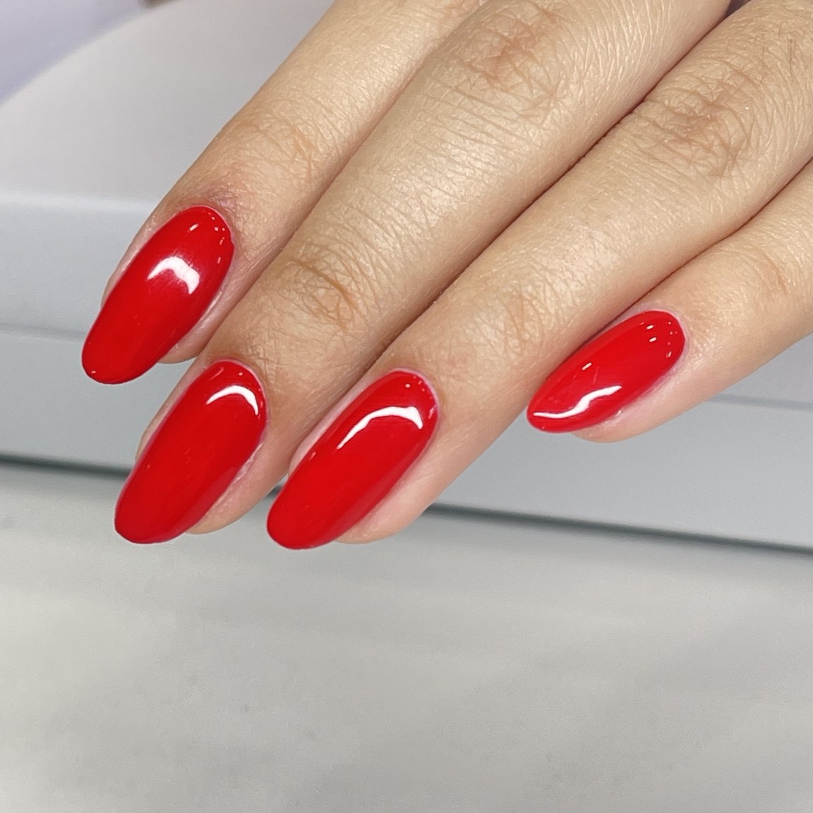 Glossy red almond-shaped nails